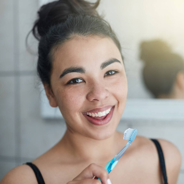 Pflege ihres gesunden Zahnfleisches und ihrer gesunden Zähne. Porträt einer attraktiven jungen Frau beim Zähneputzen im Badezimmer. - Foto, Bild