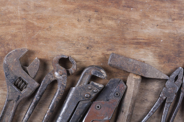 Old construction tools a lot of rust and scratches on a wooden table Closeup - 写真・画像