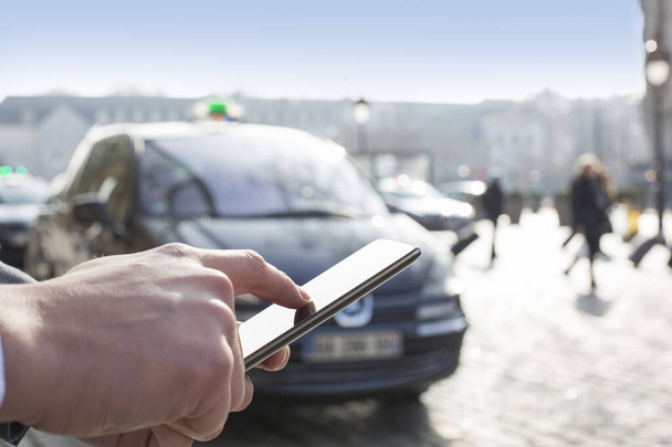 Man orders a taxi from his mobile phone. Close-up hands - Foto, Imagem