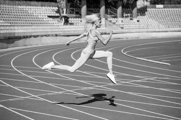 спортивная женщина в спортивной одежде работает на стадионе, скорость - Фото, изображение