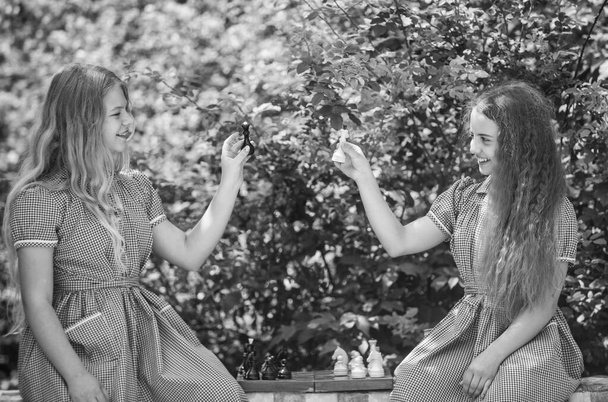 two teen girls play chess in retro dress outdoor, childhood - Foto, Imagem
