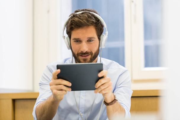 One man playing a video game on digital tablet interior - Fotó, kép