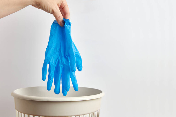 person throwing away  rubber gloves  in trash bin  - Φωτογραφία, εικόνα
