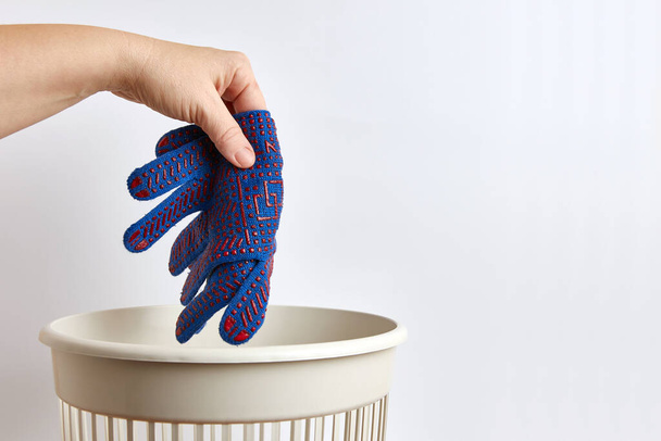 person throwing away  rubber gloves  in trash bin  - 写真・画像