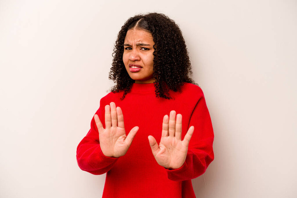 Young African American woman isolated on white background rejecting someone showing a gesture of disgust. - Фото, зображення