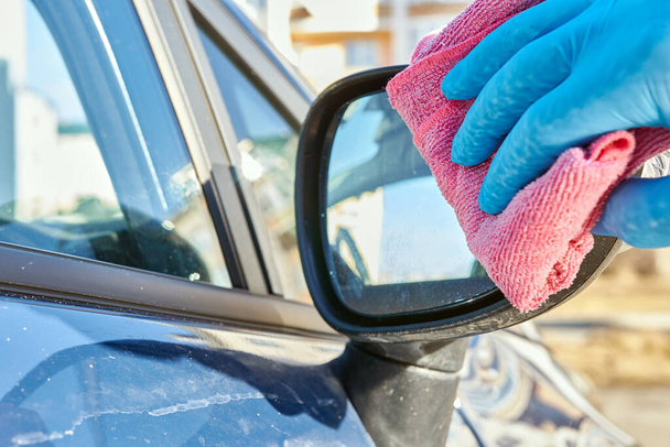 person hand in glove  washing the car mirror  - Foto, Imagen
