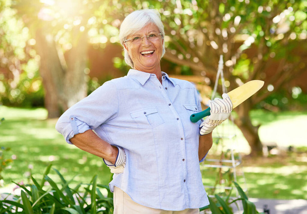 Welcome to my beautiful garden. Portrait of a happy senior woman enjoying a bit of gardening. - Valokuva, kuva
