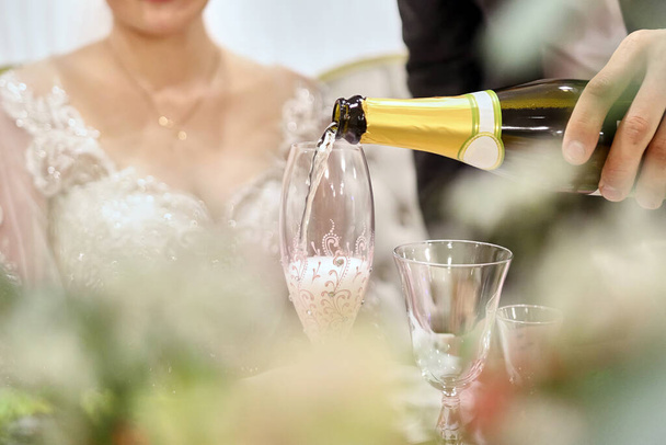 sposa e sposo in possesso di bottiglia di champagne  - Foto, immagini