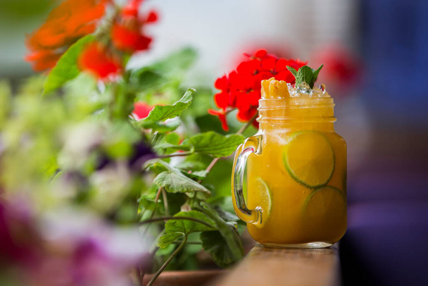 Glass of ice tea on background of flowers - Photo, image