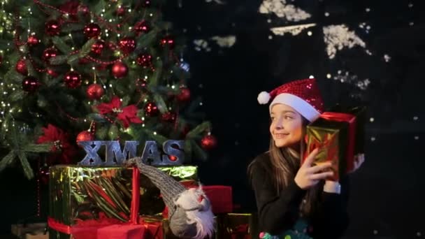 With Merry Christmas and Happy New Year. Beautiful, little girl with a gift in the New Years atmosphere - Záběry, video
