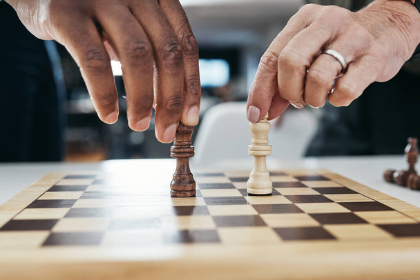 Think carefully about your next move. Shot of two unrecognizable businesspeople playing a game of chess together inside their office at work. - 写真・画像