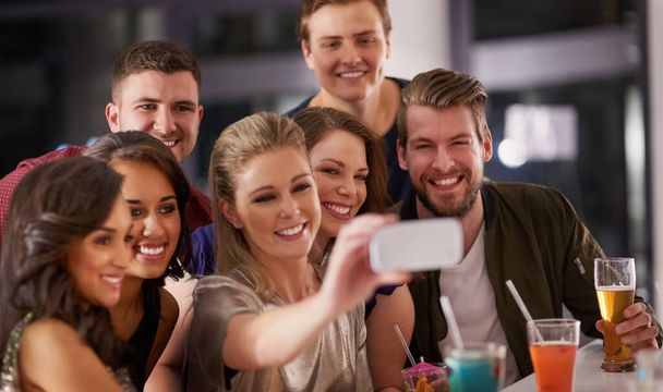Nepotřebujeme výmluvu pro selfie. Zastřelen šťastnou skupinu přátel, kteří si dávají selfie, když spolu popíjejí v baru. - Fotografie, Obrázek