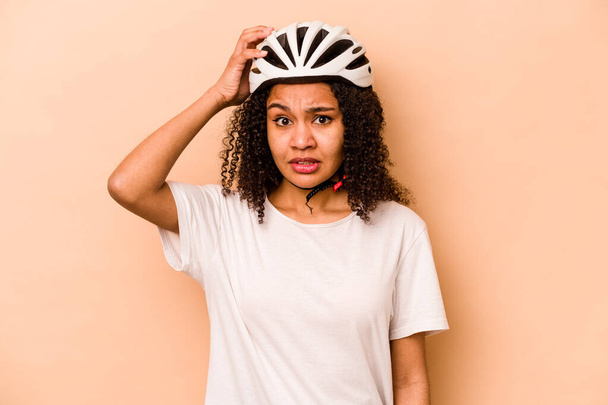 Молода іспаномовна жінка в шолом-велосипеді ізольована на синьому фоні, шокує, вона пам'ятає важливу зустріч
. - Фото, зображення