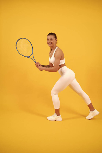 heureuse jeune fille en tenue de sport courir avec raquette. Une sportive. femme énergique - Photo, image