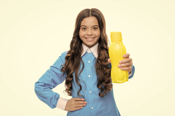 Gelukkig kind geven geel plastic drinkwater fles voor verblijf gehydrateerd, wellness - Foto, afbeelding
