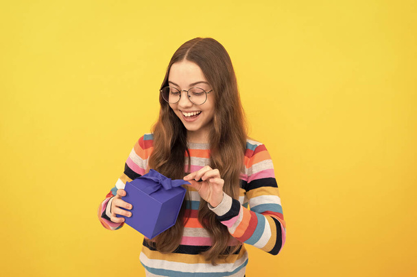 verblüfftes Kind in Brille öffnet Geschenkbox für Urlaub, Staunen - Foto, Bild