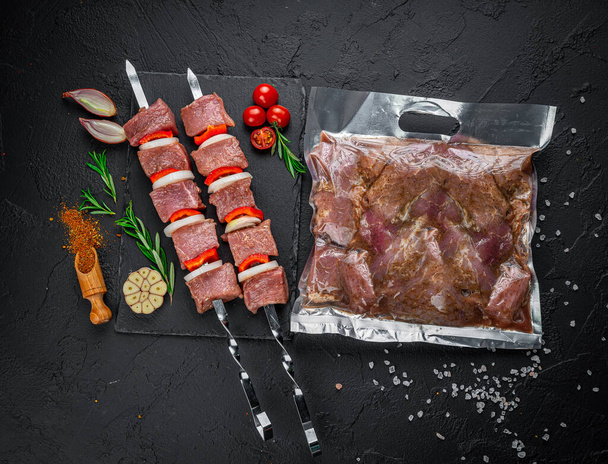 Vacuum-packed grilled meat, on a dark background. - Fotoğraf, Görsel