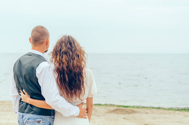uomo e donna in piedi sulla riva e guardando il mare - Foto, immagini