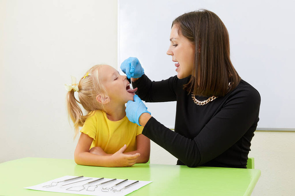 Мовний терапевт, що працює з маленькою дівчинкою в офісній підготовці вимова
 - Фото, зображення