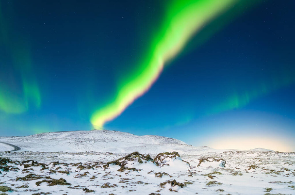 Aurora Borealis. Северное сияние над горами. Зимний ночной пейзаж с яркими огнями в небе. Пейзаж на севере зимой. Популярное место для путешествий. - Фото, изображение