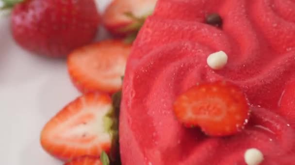 Close up of a pink strawberry cake swirling on a white plate. - Metraje, vídeo