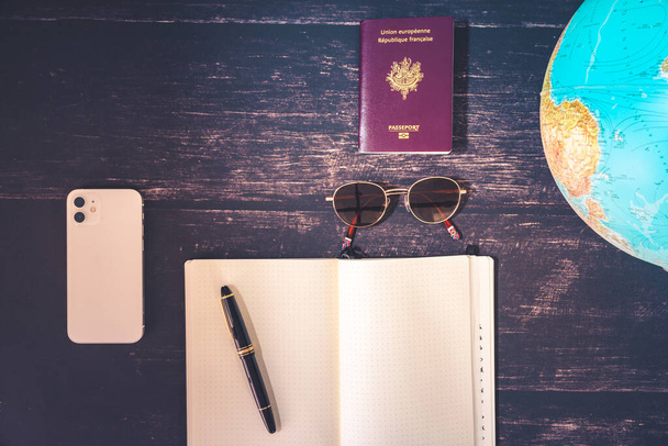World map and items on wooden background, flat lay. summer travel wanderlust concept, space for text. map camera sunglasses passport phone pen mask book on wooden background top view. planning vacation concept. - Fotó, kép