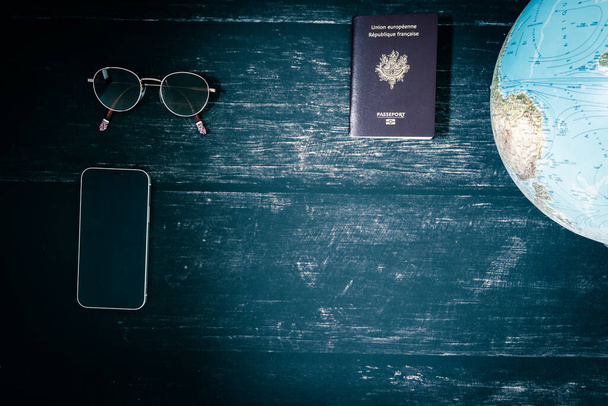 World map and items on wooden background, flat lay. summer travel wanderlust concept, space for text. map camera sunglasses passport phone pen mask book on wooden background top view. planning vacation concept. - Foto, Imagem