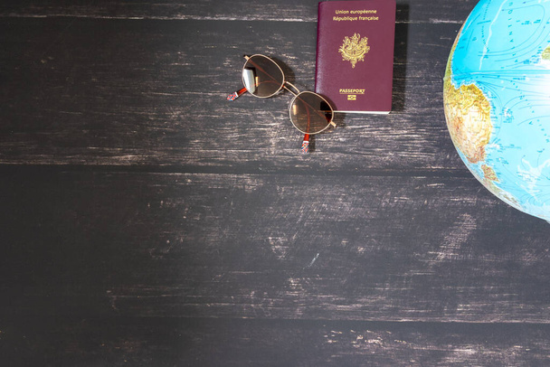 World map and items on wooden background, flat lay. summer travel wanderlust concept, space for text. map camera sunglasses passport phone pen mask book on wooden background top view. planning vacation concept. - Φωτογραφία, εικόνα
