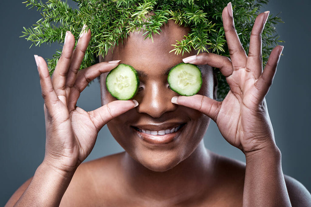 Cucumber you later. Shot of a woman holding cucumber slices over her eyes while wearing a leaf wreath. - Photo, Image