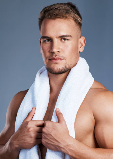 My skin is healthy and protected against dryness. Shot of a handsome young man posing with a towel around his neck. - Foto, imagen