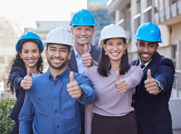 Leave the building to us. Shot of a diverse group of businesspeople standing together and showing a thumbs up while wearing hardhats. - Photo, Image