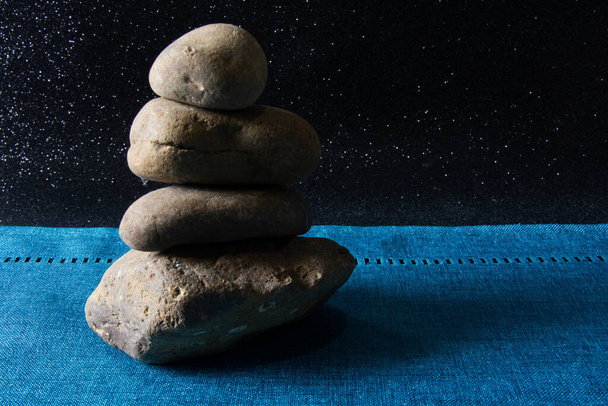 Stone totem on a blue and black background - Fotografie, Obrázek