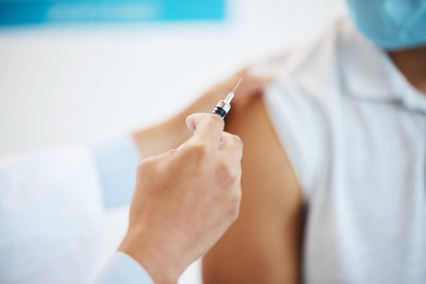 Êtes-vous prêts ? Plan d'un médecin méconnaissable injectant le vaccin Covid à sa patiente dans sa clinique. - Photo, image