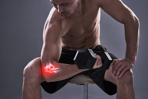 Rehabilitating his elbow. Cropped shot of a young man in the studio with cgi highlighting his elbow injury. - Foto, imagen