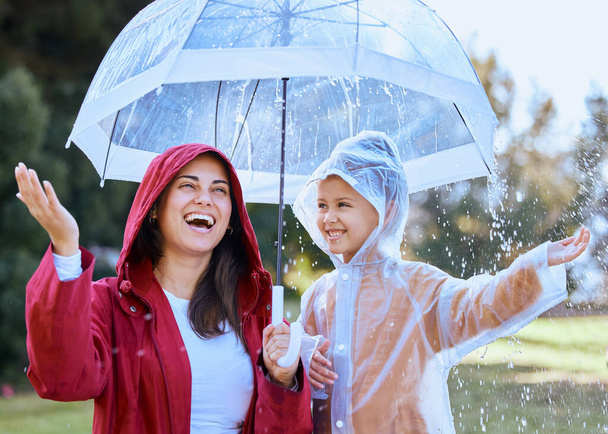 Annem her şeyi eğlenceli hale getiriyor. Yağmurda kızıyla oynayan bir annenin fotoğrafı.. - Fotoğraf, Görsel