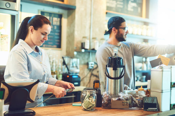 Su café siempre está ocupado. Fotografía de dos jóvenes emprendedores trabajando en su cafetería. - Foto, Imagen