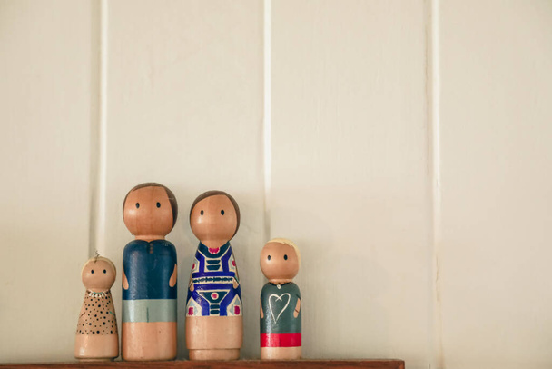 Expositor de figuras familiares de madera con fondo blanco. Familia nuclear con madre, padre, hermana y hermano. - Foto, Imagen