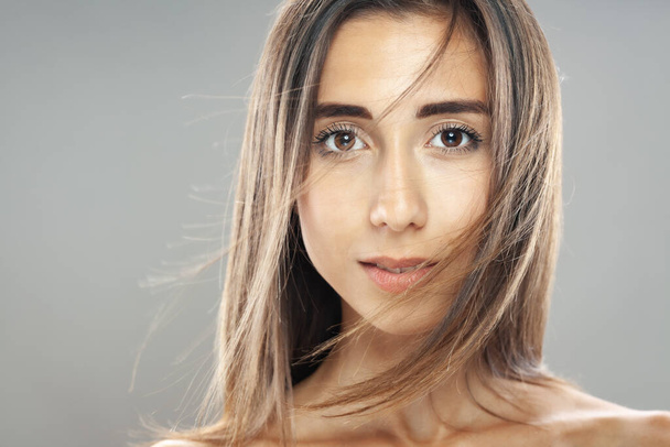 Beautiful brunette girl studio portrait. Serious face expression. - Photo, image