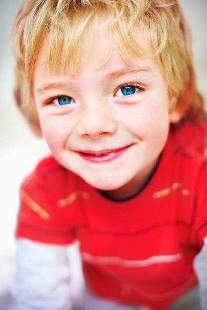Ein unschuldiger kleiner Junge, der einem ein süßes Lächeln schenkt. Nahaufnahme Porträt eines unschuldigen kleinen Jungen, der dir ein süßes Lächeln schenkt. - Foto, Bild
