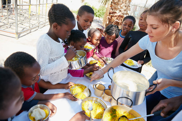 Who wants sauce. Cropped shot of children getting fed at a food outreach. - Photo, Image