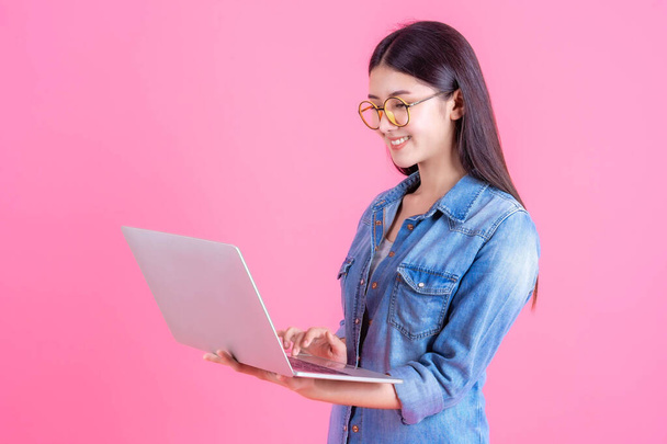 lifestyle beautiful Asian business young woman using laptop computer for online home office isolated on pink background with copy space - online shopping and online banking concept - Fotó, kép