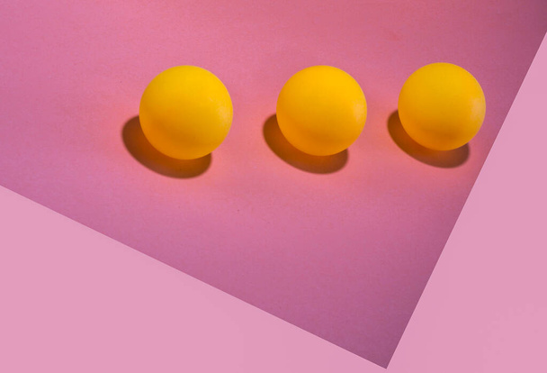 Abstract still life with three orange balls on a pink background - Foto, imagen