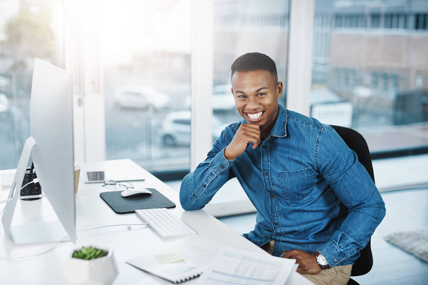 Success tastes better when youve worked hard for it. Portrait of a young businessman posing and in good spirits at his office desk. - Photo, Image
