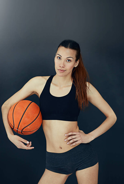 Tengo juego. Retrato de estudio de una joven atractiva sosteniendo una pelota de baloncesto. - Foto, imagen