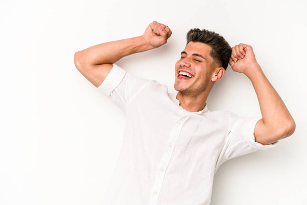 Young caucasian man isolated on white background celebrating a special day, jumps and raise arms with energy. - Photo, Image