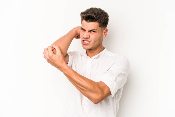 Νεαρός καυκάσιος άνδρας απομονωμένος σε λευκό φόντο με πόνο στον αυχένα λόγω άγχους, μασάζ και άγγιγμά του με το χέρι. - Φωτογραφία, εικόνα