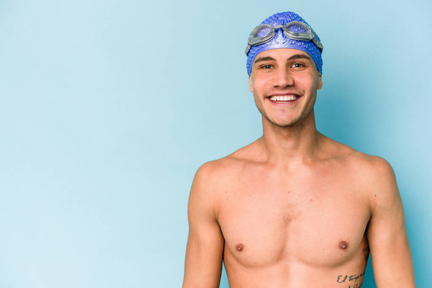Young caucasian swimmer man isolated on blue background - Foto, imagen