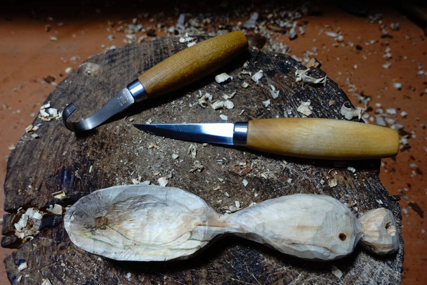drewniana łyżka wyrzeźbiona dwoma nożami na pniu drzewa - Zdjęcie, obraz