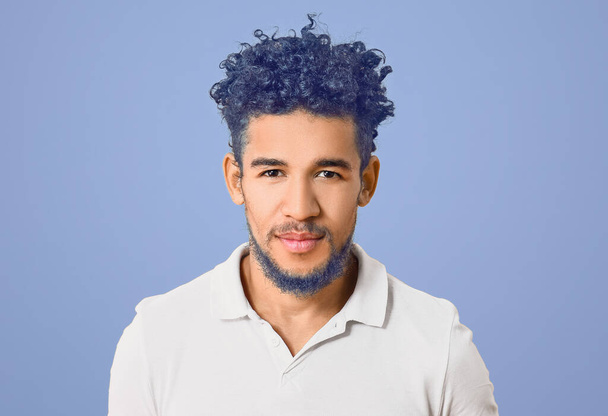 Stylish young man with unusual blue hair and beard on color background - Fotoğraf, Görsel