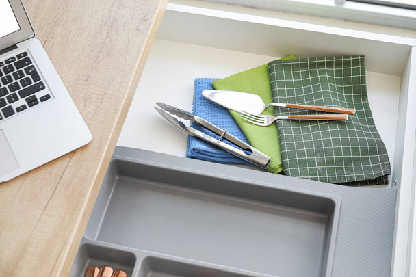 Άνοιγμα συρταριού με μαχαιροπίρουνα και χαρτοπετσέτες στη σύγχρονη κουζίνα - Φωτογραφία, εικόνα